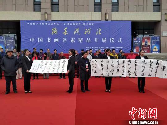 圖為書(shū)畫(huà)家在中國(guó)書(shū)畫(huà)名家精品開(kāi)展儀式現(xiàn)場(chǎng)進(jìn)行書(shū)法創(chuàng)作，并展示作品。　魯?shù)り?yáng) 攝