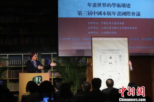山東藝術學院院長王力克贈送巨幅古版年畫并發言。　張道正 攝