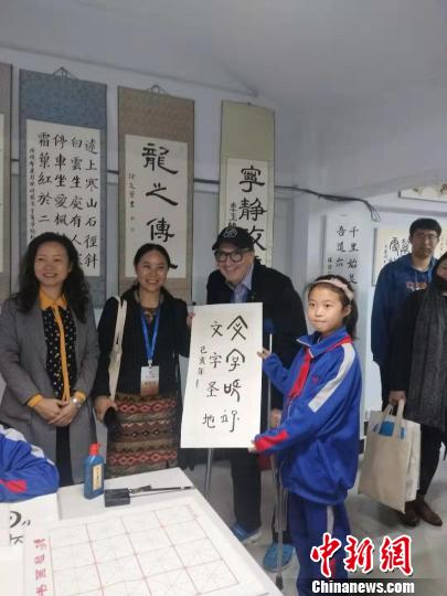 圖為外國漢學(xué)家與孩子交流書法。　楊大勇 攝