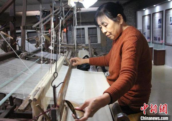 圖為工人在使用手工木織機(jī)加工傳統(tǒng)柳疃絲綢。　趙曉 攝