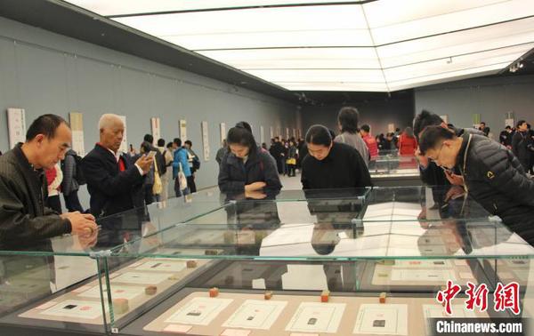 圖為觀眾在展廳內(nèi)欣賞篆刻作品?！≮w曉 攝
