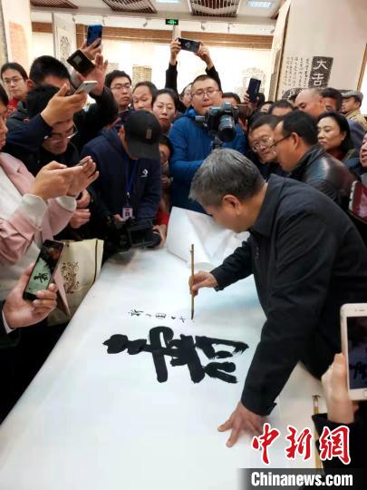 山東省書法家協(xié)會主席顧亞龍在現(xiàn)場展示書法?！∏锔?攝
