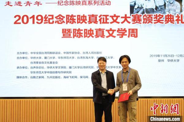 中華全國臺灣同胞聯誼會副會長鄭平(左)為“陳映真思想與創作”論文一等獎獲得者張立本頒獎。　劉沛 攝