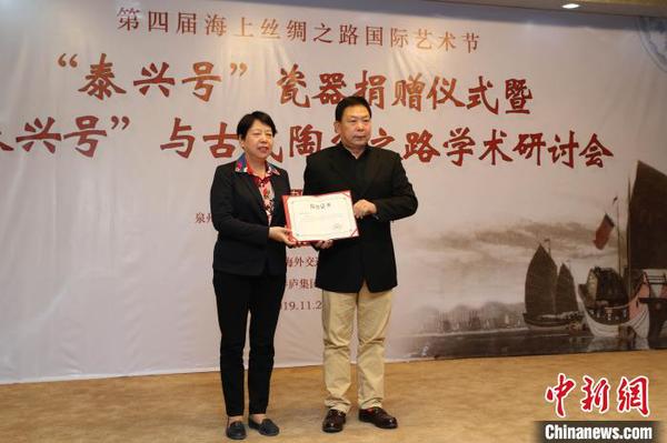 泉州市副市長(zhǎng)周真平(左)為“泰興號(hào)”沉船瓷器捐贈(zèng)者鄭長(zhǎng)來(lái)頒發(fā)收藏證書。　鐘欣 攝
