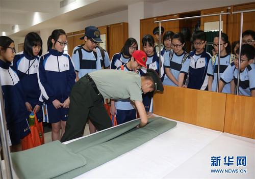 駐澳門部隊在軍營開放活動中邀請市民走進軍營參觀，戰士們向小學生演示疊軍被（2017年8月24日攝）。 新華社發（葉華敏 攝）