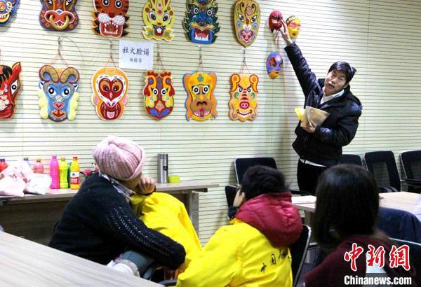 資料圖：濟南侯氏社火臉譜第六代傳人侯志新向學生講授社火臉譜繪制工藝。　趙曉 攝