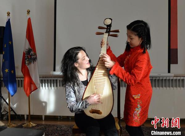 圖為中國文化小使者琵琶獨奏《彝族舞曲》，霓娜體驗琵琶指法。主辦方供圖