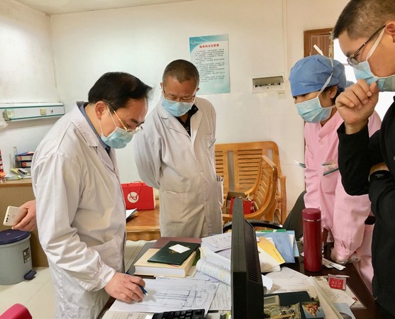 左萬里（左一）深入醫院感染科一線部署防控工作