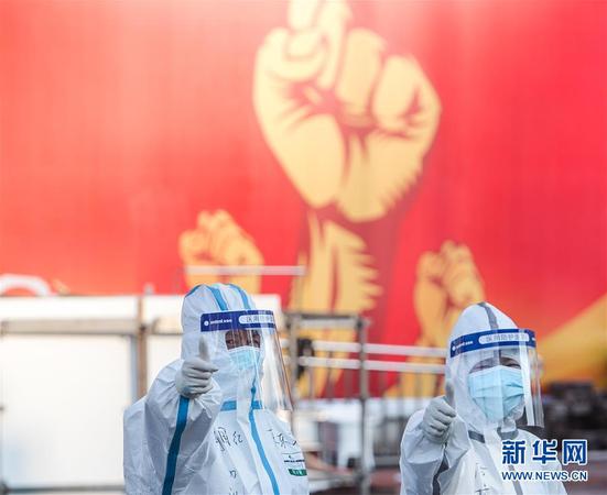 2月12日，兩名醫務人員在武漢體育中心方艙醫院前豎起拇指為自己和同伴加油鼓勁。 新華社記者 肖藝九 攝