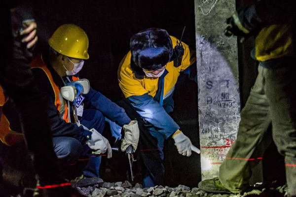 機械工隊長侯寧與03506清篩車組車隊長核對清篩后的線路標高，嚴把施工質量關。（攝影 賈佳）