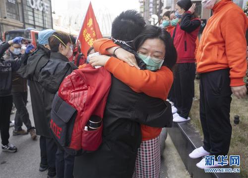 3月17日，在武漢市武昌區駐地，江西醫療隊員（前右）擁抱送別青海醫療隊員。青海醫療隊當日返程，兩家醫療隊在同一個駐地也在同一個方艙共事，結下了深厚的感情。 當日，承擔方艙醫院醫療救治任務的援鄂醫療隊陸續開始撤離。 新華社記者 才揚 攝
