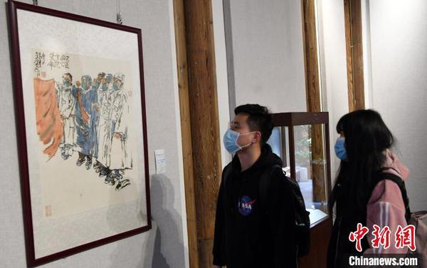 二名青年觀看“守望相助 萬眾一心——抗疫藝術作品展”。　記者劉可耕 攝