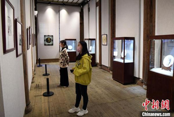 二名女青年觀看該展覽參展作品。　記者劉可耕 攝