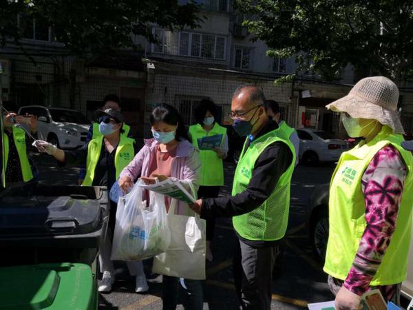 委員們幫助居民對(duì)垃圾進(jìn)行分類(lèi)投放