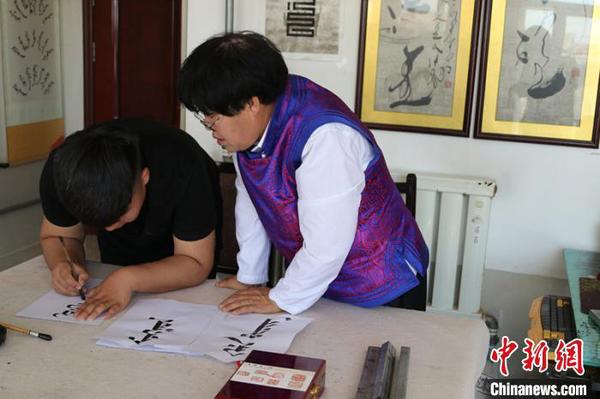圖為那布查指導兒子學習蒙古文書法。　張美娜 攝