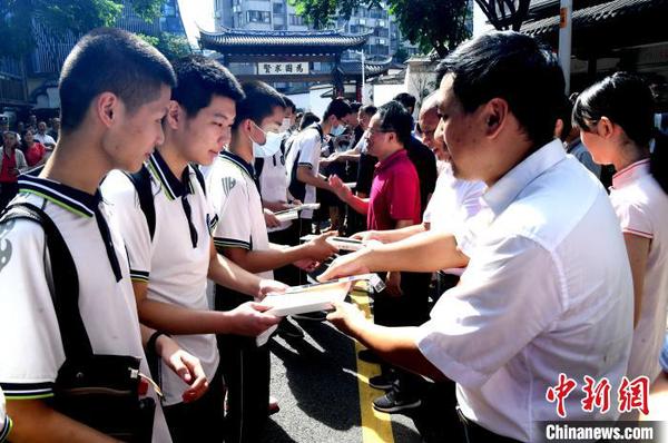 嘉賓向?qū)W子代表贈書及狀元筆。　記者劉可耕 攝