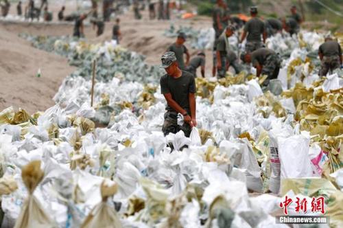 資料圖：7月25日，江西省九江市柴桑區(qū)江洲鎮(zhèn)北堤，中國(guó)人民解放軍第71集團(tuán)軍某部官兵正在為防洪備料。