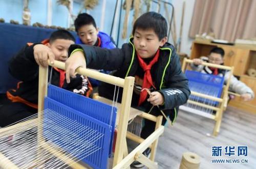 12月22日，浣紗小學五年級學生在用苧麻線織布。