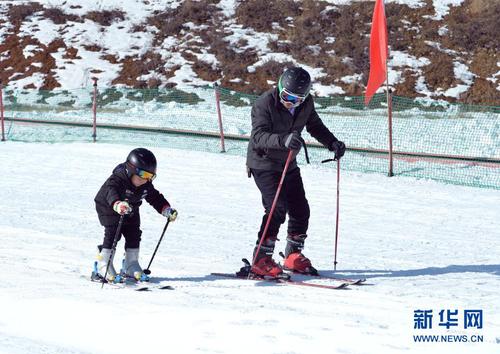 12月27日，在婭豪國際滑雪場內(nèi)，一名兒童在大人的指導(dǎo)下學(xué)習(xí)滑雪。