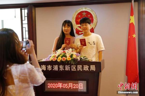 資料圖：兩位市民手持結(jié)婚證合影留念。 殷立勤 攝