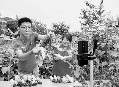 山西平順縣南坡村大學(xué)生王亞鵬（左）回村創(chuàng)業(yè)成為“新農(nóng)人”，圖為他正在直播銷售農(nóng)產(chǎn)品。新華社發(fā)