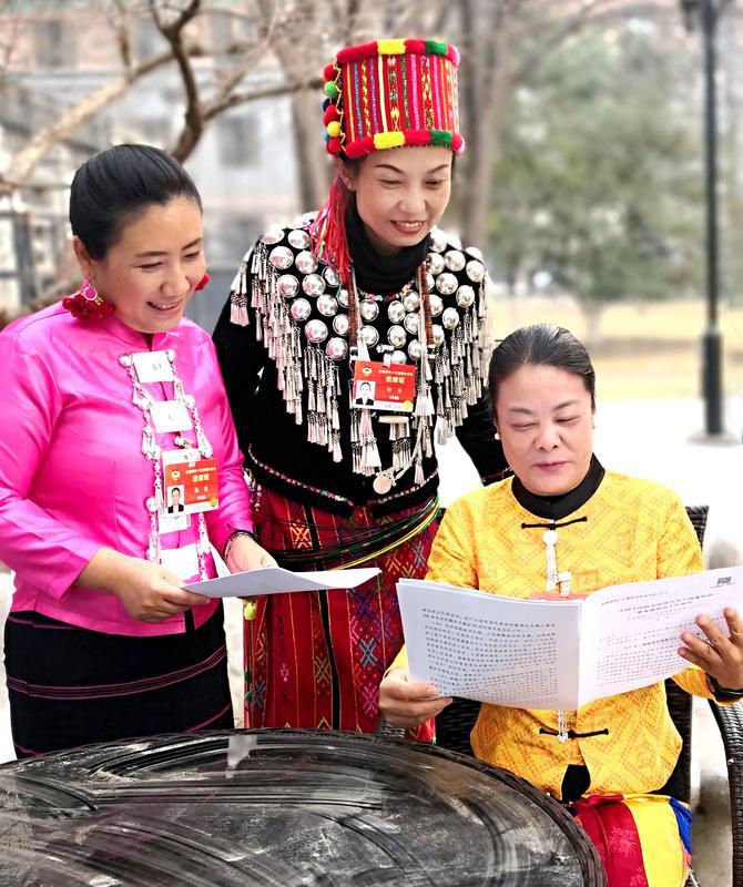 少數民族界楊艷、何慶、黃麗云三位委員（從左至右）就全國政協常委會工作報告中共同關注的話題進行交談。特邀委員記者 資艷 萍 攝