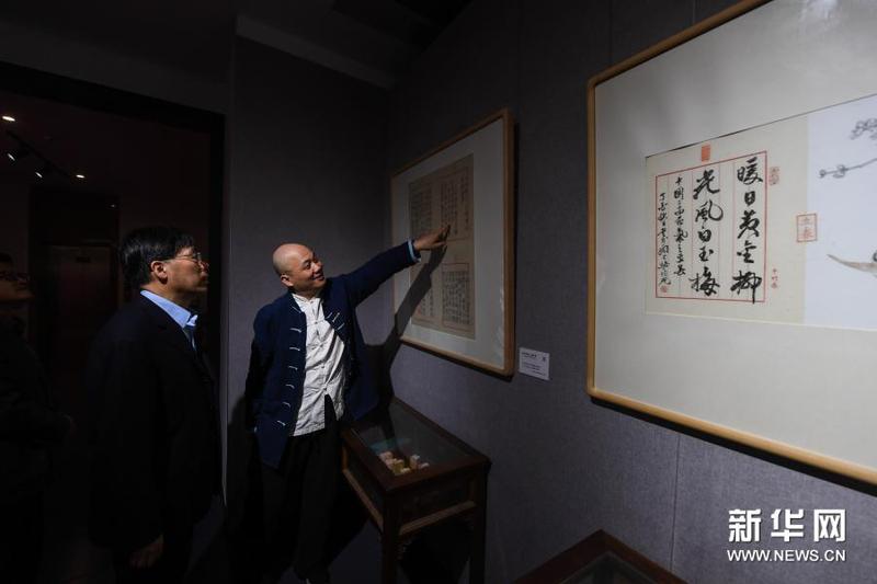 3月16日，在浙江理工大學(xué)絲綢博物館內(nèi)，國家級非遺項(xiàng)目木版水印技藝代表性傳承人魏立中（右）為觀眾介紹木版水印作品。新華社記者 徐昱 攝