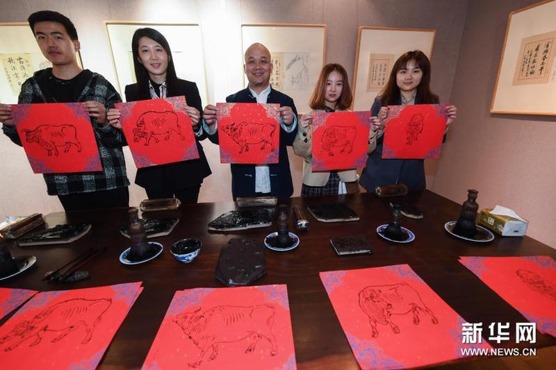 3月16日，在浙江理工大學(xué)絲綢博物館內(nèi)，國家級非遺項(xiàng)目木版水印技藝代表性傳承人魏立中（中）與師生展示剛印制的木版水印作品。新華社記者 徐昱 攝