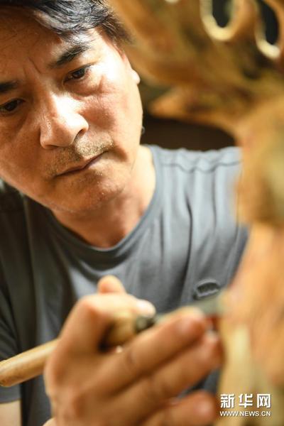5月24日，徐惠東在位于下涯村的工作室進行木雕創作。新華社記者 翁忻旸 攝
