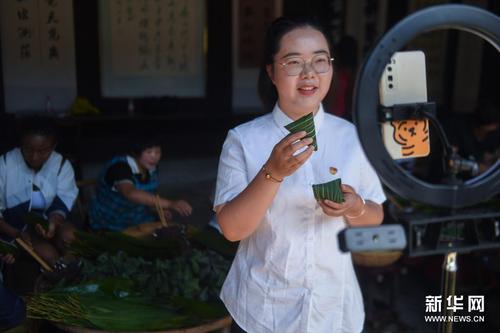 6月8日，湖源鄉(xiāng)的青年黨員志愿者通過直播帶貨的形式為特色灰湯粽擴大知名度。新華社記者 徐昱 攝