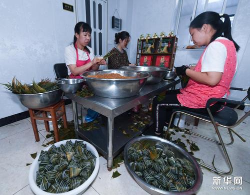 　6月8日，湖源鄉(xiāng)窈口村村民在制作不同口味的灰湯粽，作為端午節(jié)特色旅游商品銷售給游客。新華社記者 徐昱 攝
