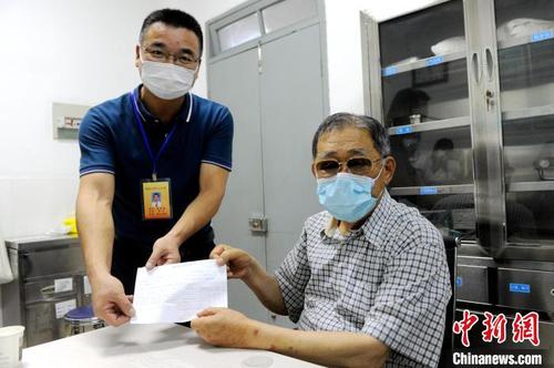 舊鎮(zhèn)衛(wèi)生院相關負責人把蓋好章的預防接種憑證遞給大陸知名臺商李瑞河(右)。　張金川 攝