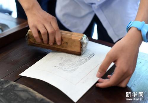 7月10日，杭州觀成實驗學校一名學生在展覽現(xiàn)場體驗十竹齋木版水印技藝。新華社記者 韓傳號 攝