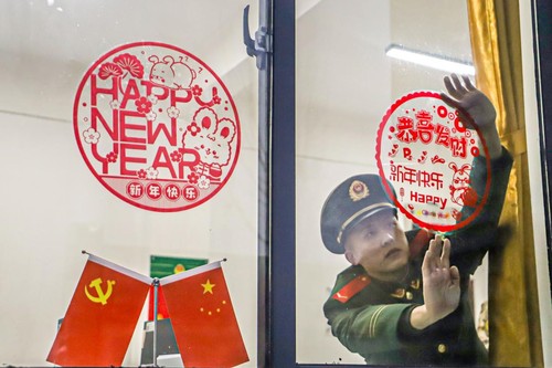 2023年1月17日，河南總隊(duì)商丘支隊(duì)組織官兵在營區(qū)開展寫春聯(lián)、掛燈籠、貼窗花、曬年貨等活動(dòng)，豐富官兵精神文化生活，營造出喜慶祥和的春節(jié)氛圍。圖為官兵正在張貼窗花。李永超攝