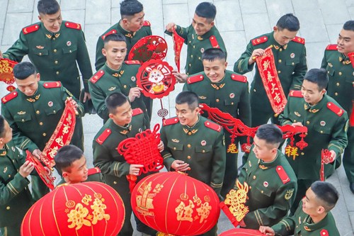 2023年1月17日，河南總隊(duì)商丘支隊(duì)組織官兵在營區(qū)開展寫春聯(lián)、掛燈籠、貼窗花、曬年貨等活動(dòng)，豐富官兵精神文化生活，營造出喜慶祥和的春節(jié)氛圍。圖為官兵正在挑選心儀飾品。李永超攝