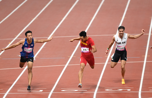 中國選手謝震業（中）沖過終點。