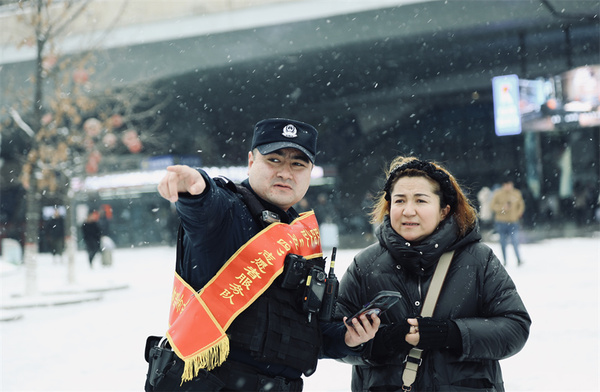 在烏魯木齊新客站，烏魯木齊市公安局特警五支隊(duì)的志愿服務(wù)隊(duì)開展服務(wù)引導(dǎo)工作。白樺 攝