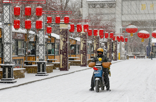 外賣員在烏魯木齊高新區(qū)（新市區(qū)）溫州街附近配送外賣，將大眾所需配送到位。謝龍 攝