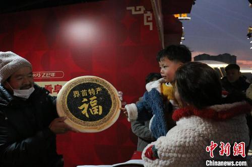 1月13日傍晚，在安徽阜陽(yáng)市阜南縣舉行的“文旅惠民促消費(fèi) 歡歡喜喜過(guò)大年”2025年春節(jié)安徽文旅主題活動(dòng)暨阜陽(yáng)“千集百會(huì)促消費(fèi)”活動(dòng)現(xiàn)場(chǎng)，來(lái)自界首市的特產(chǎn)福字“壯饃”，受到市民歡迎。劉浩 攝